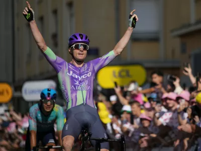 Switzerland's Mauro Schmid celebrates as he crosses the finish line to win the thirteenth stage of the Tour de France cycling race with start in Dole and finish in Belfort, France, Friday, July 17, 2026. (AP Photo/Mosa'ab Elshamy)