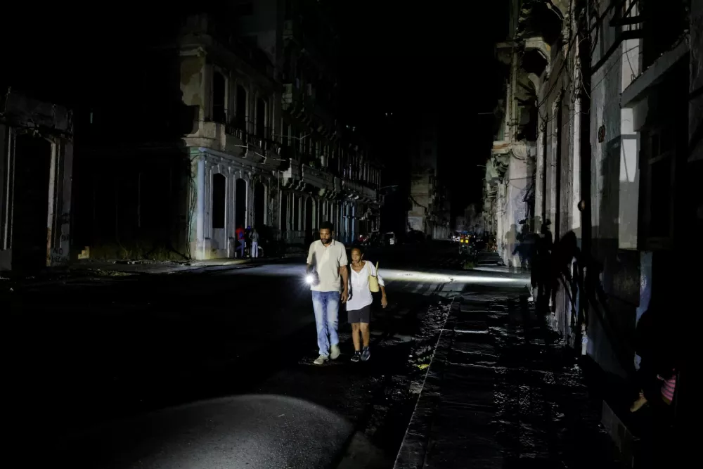 People walk down a street as Cuba's national power grid collapsed, marking the third major outage in nine days, in Havana, Cuba, July 14, 2026. REUTERS/Norlys Perez