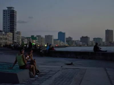 People hang out on the Malecon seawall at dusk during a blackout in Havana, Cuba, Tuesday, July 14, 2026 (AP Photo/Ramon Espinosa)