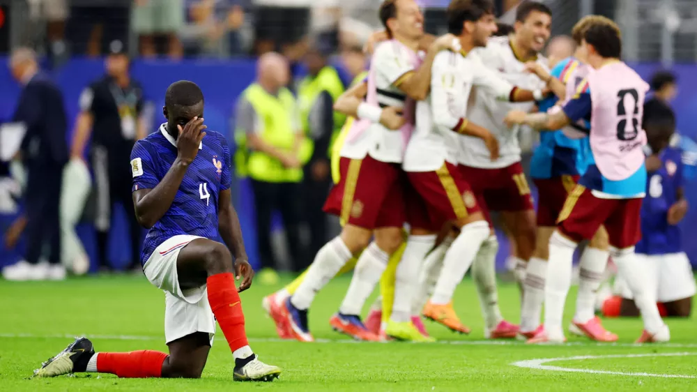 Soccer Football - FIFA World Cup 2026 - Semi Final - France v Spain - Dallas Stadium, Arlington, Texas, U.S. - July 14, 2026 France's Dayot Upamecano look dejected after the match as France are eliminated as Spain players celebrate after qualifying for the World Cup final REUTERS/Albert Gea