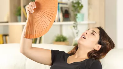 Girl suffering heat stroke fanning on a sofa / Foto: Antonioguillem Getty Images