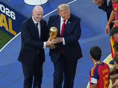 FIFA President Gianni Infantino and President Donald J. Trump present the trophy to Spain's Rodri (16) after the World Cup final soccer match between Spain and Argentina in East Rutherford, N.J., near New York, Sunday, July 19, 2026. (AP Photo/Matt Rourke)