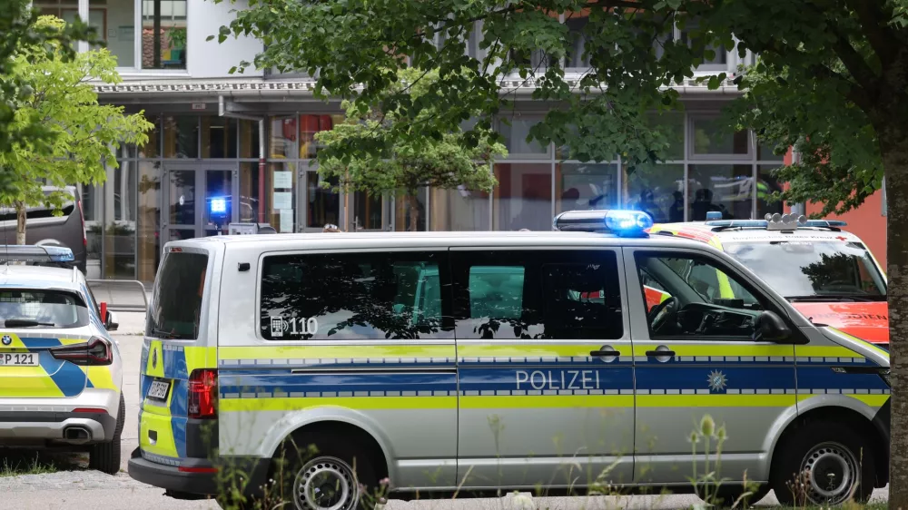 Police vehicles are parked in front of the Welfen High School, Schongau, Germany, Wednesday, July 8, 2026. (Karl-Josef Hildenbrand/dpa via AP)