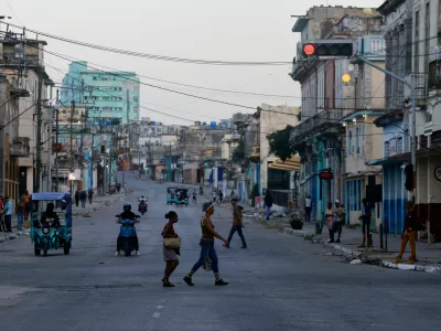 People cross a street as Cuba's national power grid is restored following its collapse, which marked the third major outage in nine days, in Havana, Cuba, July 15, 2026. REUTERS/Norlys Perez