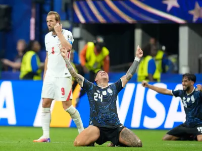 Argentina's Enzo Fernandez and Nico Gonzalez, right, celebrate at the end of the World Cup semifinal soccer match between England and Argentina as England's Harry Kane walks behind, in Atlanta, Wednesday, July 15, 2026. (AP Photo/Rebecca Blackwell)