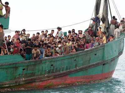 Migrants sit on their boat as they wait to be rescued by Acehnese fishermen on the sea off East Aceh, Indonesia, Wednesday, May 20, 2015. Hundreds of migrants stranded at sea for months were rescued and taken to Indonesia, officials said Wednesday, the latest in a stream of Rohingya and Bangladeshi migrants to reach shore in a growing crisis confronting Southeast Asia. (AP Photo/S. Yulinnas)