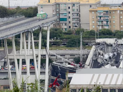 Cars are blocked on the Morandi highway bridge after a section of it collapsed, in Genoa, northern Italy, Tuesday, Aug. 14, 2018. A large section of the bridge collapsed over an industrial area in the Italian city of Genova during a sudden and violent storm, leaving vehicles crushed in rubble below. (AP Photo/Antonio Calanni)