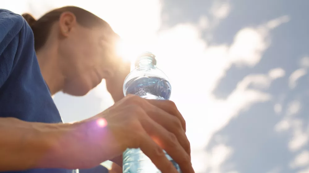 Woman drinking water in extreme summer heat wave. / Foto: Kieferpix Getty Images