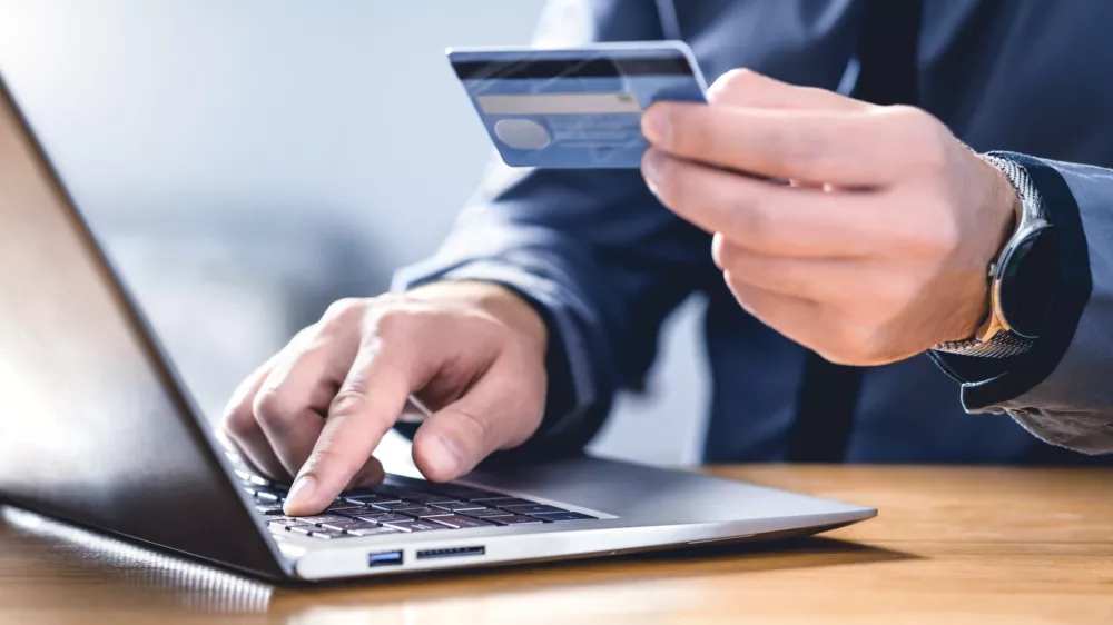Safe online payment and electronic money transfer security. Pay with digital technology. Man using credit card and laptop to login to internet bank. Financial safety to prevent scam, threat and fraud.