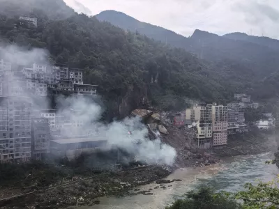 In this photo taken and provided by Mimosa shows smoke rise as resident buildings toppled by rocks and muds following a landslide in Pengshui County in southwestern China's Chongqing on Friday, July 17, 2026. (Mimama via AP)