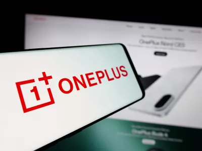 In this photo illustration, a smartphone with the logo of company OnePlus Technology (Shenzhen) Co. Ltd is seen on screen in front of website.
