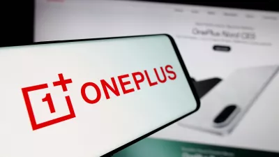 In this photo illustration, a smartphone with the logo of company OnePlus Technology (Shenzhen) Co. Ltd is seen on screen in front of website.