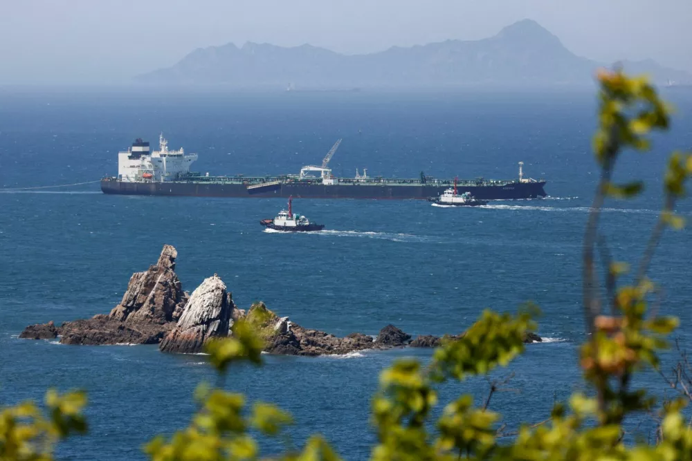 FILE PHOTO: Tugboats guide the crude oil tanker Odessa, carrying UAE crude after passing through the Strait of Hormuz with its Automatic Identification System transponder turned off, navigates the waters at Daesan port, where it is expected to discharge crude oil, in Seosan, South Korea, May 8, 2026. REUTERS/Kim Soo-hyeon/File Photo