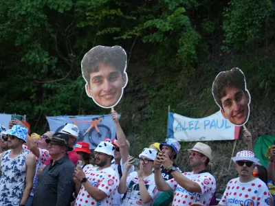 Spectators wave pictures of France's Paul Seixas in the Alpe d'Huez during the nineteenth stage of the Tour de France cycling race with start in Gap and finish in Alpe d'Huez, France, Friday, July 24, 2026. (AP Photo/Mosa'ab Elshamy)