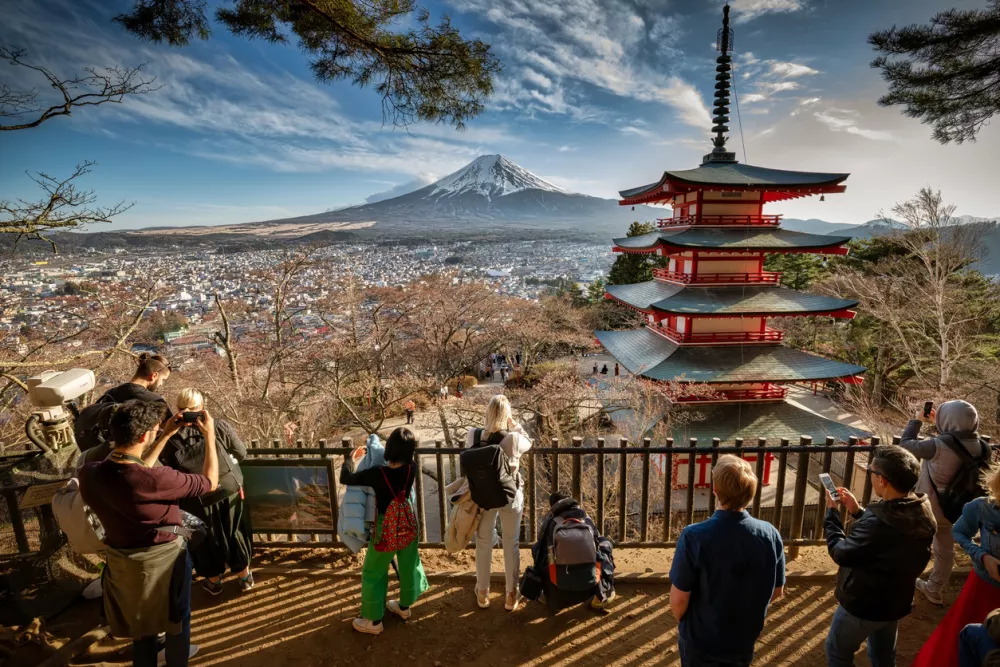 Fujiyoshida, Yamanashi / Japan - April 5, 2019: Tourists taking photos of the Chureito Pagoda with Mount Fuji in the background.