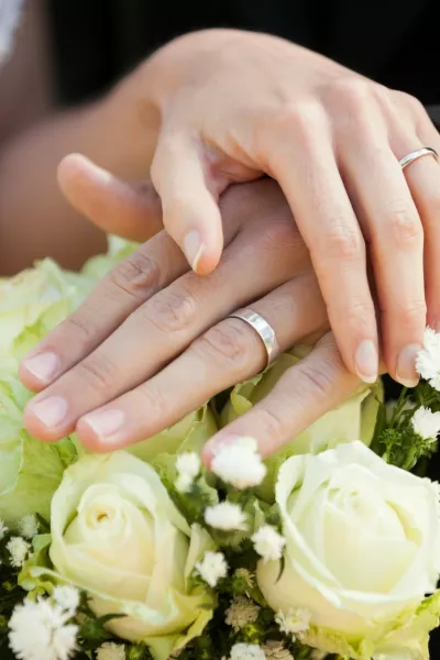 Close-up mid section of a newlywed couple with wedding rings and bouquet,Image: 187824776, License: Royalty-free, Restrictions:, Model Release: yes / Foto: Profimedia