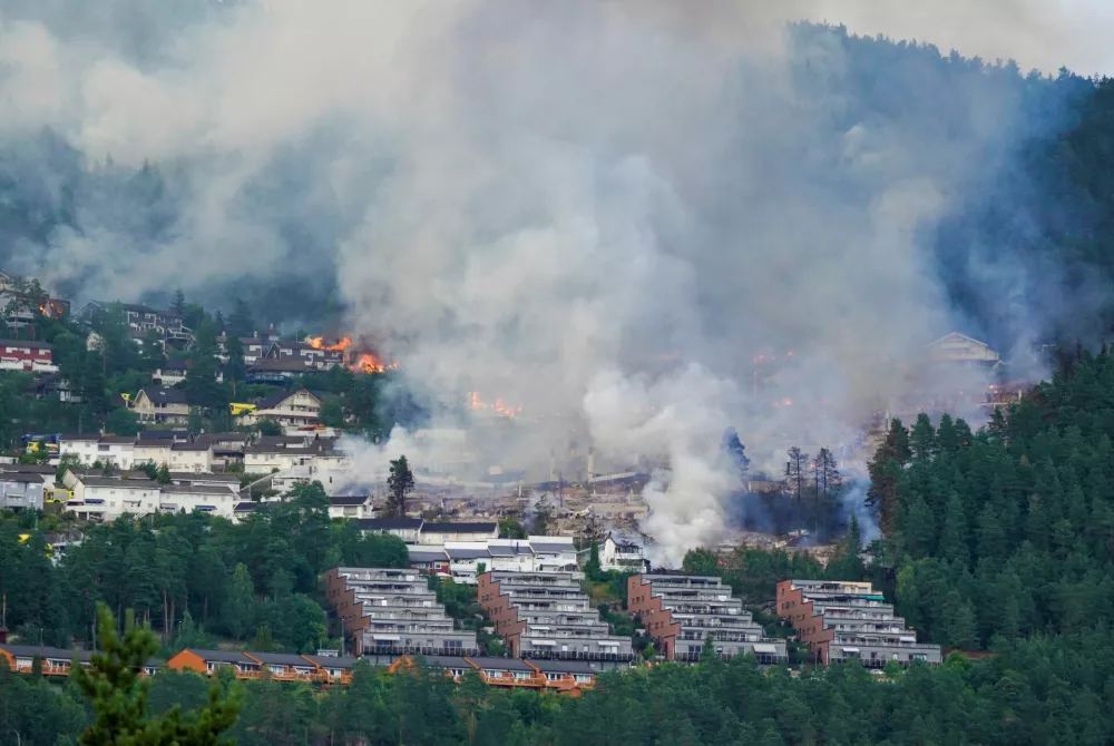 Smoke rises from a large fire that has spread from terraced houses in Krokstadelva, Drammen municipality, Norway, July 17, 2026. More than 50 homes were destroyed by fire on Friday near the city of Drammen in southern Norway as firefighters battled to contain the flames amid strong winds, rescue officials said. Thomas Fure/NTB/via REUTERS  ATTENTION EDITORS - THIS IMAGE WAS PROVIDED BY A THIRD PARTY. NORWAY OUT. NO COMMERCIAL OR EDITORIAL SALES IN NORWAY.