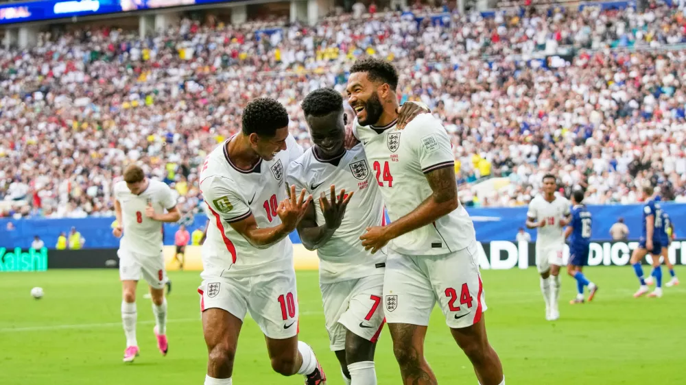 England's Bukayo Saka (7) celebrates with Jude Bellingham (10) and Reece James (24) after scoring their fifth goal, his third, during the World Cup third-place playoff soccer match between France and England in Miami Gardens, Fla., Saturday, July 18, 2026. (AP Photo/Lynne Sladky)