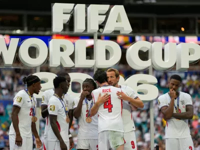 England's Harry Kane (9) embraces Declan Rice during the presentation after the World Cup third-place playoff soccer match between France and England in Miami Gardens, Fla., Saturday, July 18, 2026. (AP Photo/Rebecca Blackwell)