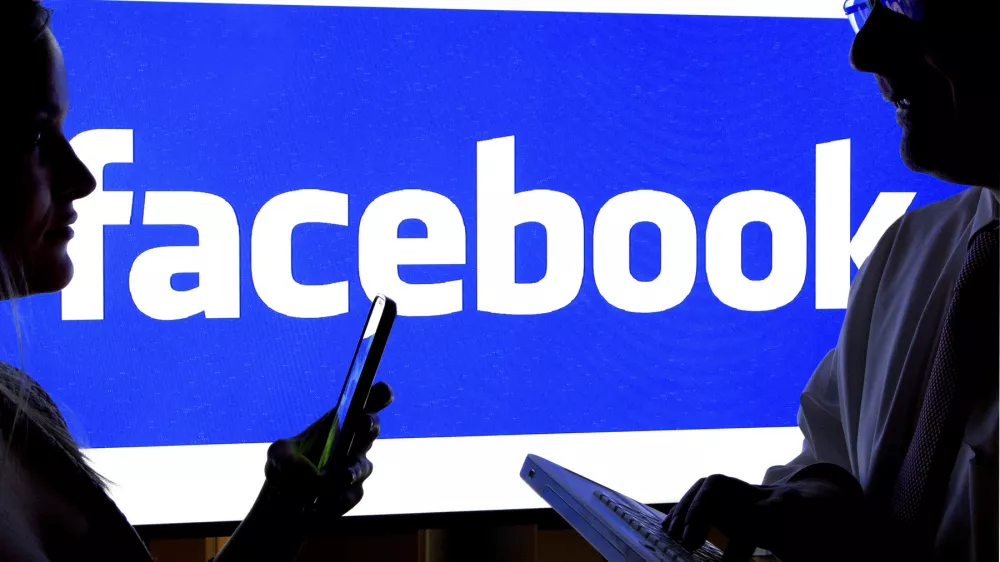 Woman and a man with smartphones in front of Facebook logo, 12.01.2016,Image: 856407758, License: Rights-managed, Restrictions:, Model Release: no / Foto: Jochen Eckel Via Profimedia