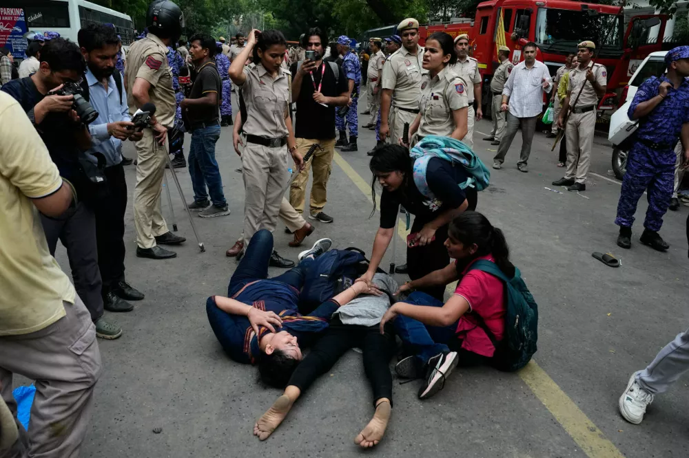 Injured supporters of the Cockroach Janta Party lie on the ground during clashes with police as they attempt to march toward India's Parliament, demanding the resignation of the education minister, in New Delhi, India, Monday, July 20, 2026.(AP Photo/Manish Swarup)