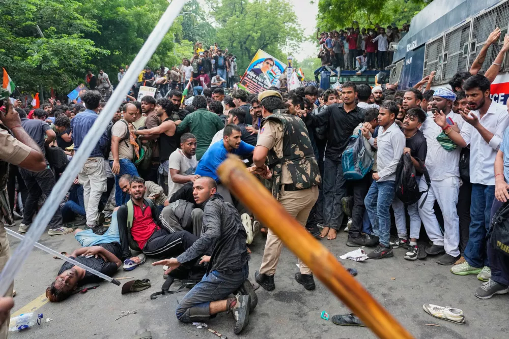 Police use batons to disperse supporters of the Cockroach Janta Party as they attempt to march toward India's Parliament, demanding the resignation of the education minister, in New Delhi, India, Monday, July 20, 2026. (AP Photo/Manish Swarup)