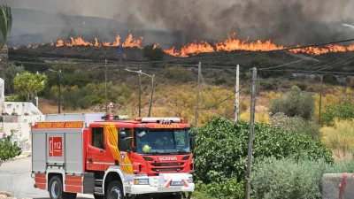 A firefighting vehicle drives by as smoke and flames rise during deadly wildfires affecting Almeria province, in Alfaix, Spain, July 10, 2026. REUTERS/Stringer