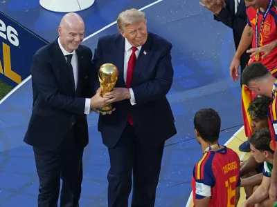 FIFA President Gianni Infantino and President Donald J. Trump present the trophy to Spain's Rodri (16) after the World Cup final soccer match between Spain and Argentina in East Rutherford, N.J., near New York, Sunday, July 19, 2026. (AP Photo/Matt Rourke)