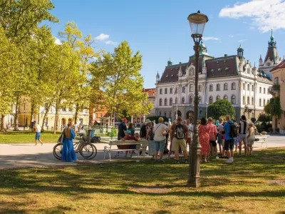 Ljubljana, Slovenia - September 4th 2022. A tour group stops to listen to their guide on a summer afternoon in Park Zvezda in the centre of Ljubljana, Slovenia