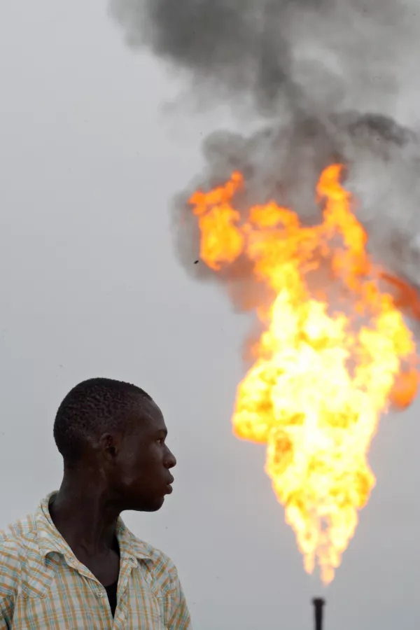 ** RETRANSMISSION FOR IMPROVED TONING ** A resident of Nigeria's oil-rich delta region looks at flames from a gas flare belonging to Italian oil company Agip in Ebocha, Nigeria, Friday, Oct. 27, 2006. Nigeria, the West African host of a December 14, 2006 OPEC meeting, has seen its oil industry hobbled by militant attacks and pipeline sabotage, making Nigeria a reminder of the vulnerabilities of world supplies as the cartel prepares to discuss production quotas. (AP Photo/George Osodi)