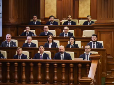 Prime Minister designate Vasile Tofan, right, on the bottom row, sits with his government team before the parliament's confidence vote in Chisinau, Moldova, Tuesday, July 21, 2026. (AP Photo/Aurel Obreja)