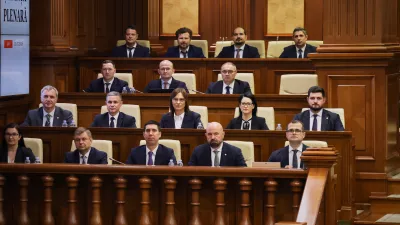 Prime Minister designate Vasile Tofan, right, on the bottom row, sits with his government team before the parliament's confidence vote in Chisinau, Moldova, Tuesday, July 21, 2026. (AP Photo/Aurel Obreja)
