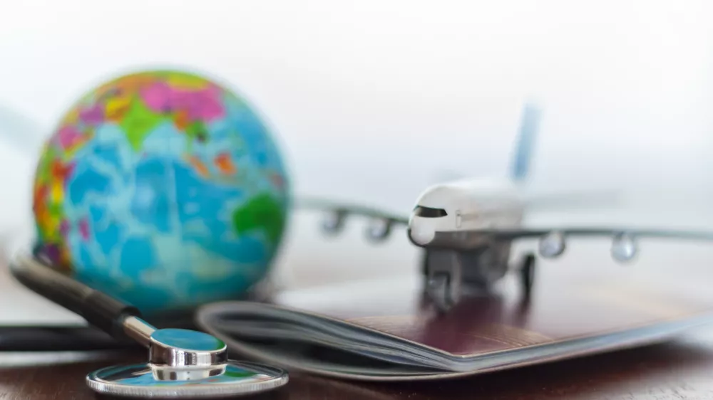Healthcare and travel insurance concept. Stethoscope, passport document, airplane and globe / Foto: Rfranca Getty Images