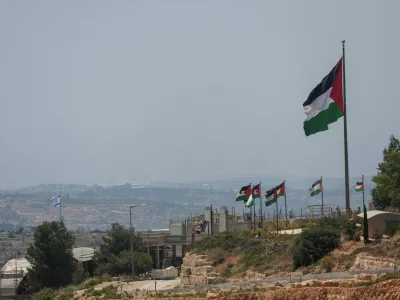 An Israeli flag flutters at a new Israeli settlement, behind Palestinians flags near Ramallah, in the Israeli-occupied West Bank, Jun 1, 2026. REUTERS/Mohammed Torokman