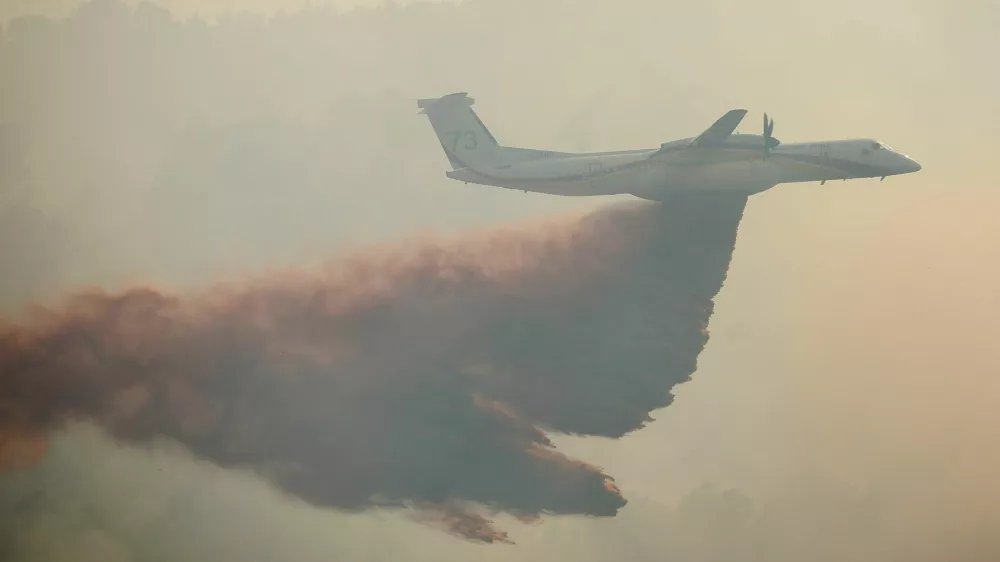 A French Civil Security Dash 8 firefighting aircraft drops retardant over a wildfire near Cotignac, in the Var department, France, amid worsening drought conditions following a heatwave and water shortages across much of the country, July 23, 2026. REUTERS/Manon Cruz