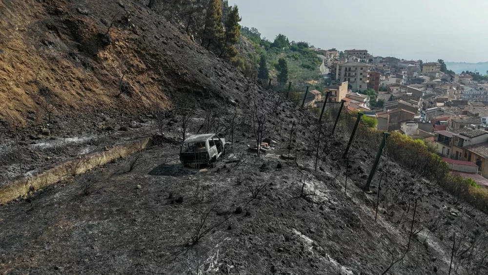 A drone view shows a burned-out vehicle and scorched vegetation on a hillside following a wildfire in Castronovo di Sicilia, Sicily, Italy, July 22, 2026. REUTERS/Danilo Arnone   TPX IMAGES OF THE DAY