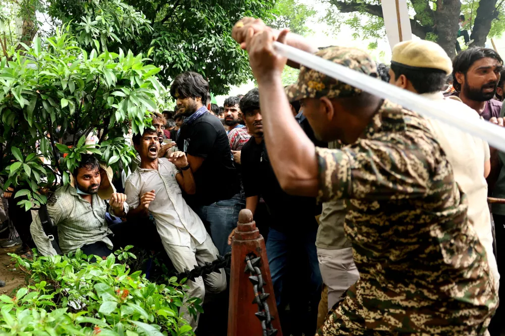A security force personnel wields his baton against demonstrators at a protest site during a planned march by supporters of India's Cockroach Janta Party towards parliament on the opening day of its monsoon session, demanding the resignation of Education Minister Dharmendra Pradhan over exam paper leaks near Jantar Mantar, New Delhi, India, July 20, 2026. REUTERS/Anushree Fadnavis  TPX IMAGES OF THE DAY