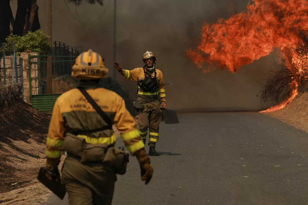 Firefighters battle a wildfire affecting Castilla y Leon province, in the village of El Tiemblo, Spain, July 24, 2026. REUTERS/Violeta Santos Moura