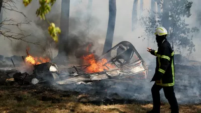 A firefighter walks next to the burning remains of a camper van during a wildfire in Lege-Cap-Ferret in the Gironde department, amid worsening drought conditions following a heatwave and water shortages across much of France, July 24, 2026. REUTERS/Stephane Mahe   TPX IMAGES OF THE DAY