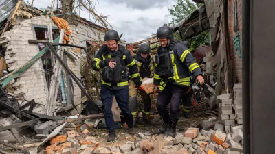 Rescuers carry a body that they removed from under the rubble of an private house following a drone attack from Russia, in Kharkiv, Ukraine, Sunday, July 26, 2026. (AP Photo/Andrii Marienko)