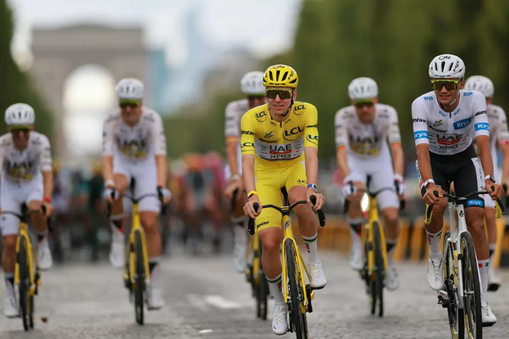 Cycling - Tour de France - Stage 21 - Paris, France - July 26, 2026 UAE Team Emirates XRG's Tadej Pogacar wearing the yellow jersey and UAE Team Emirates XRG's Isaac Del Toro wearing the white jersey in action with other cyclists during stage 21 REUTERS/Stephanie Lecocq