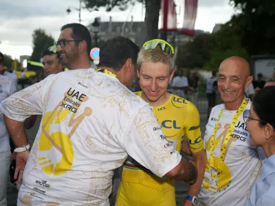 Slovenia's Tadej Pogacar, wearing the overall leader's yellow jersey, celebrates with his teammates after the last stage of the Tour de France cycling race with start and finish in Paris, Sunday, July 26, 2026. (AP Photo/Mosa'ab Elshamy)