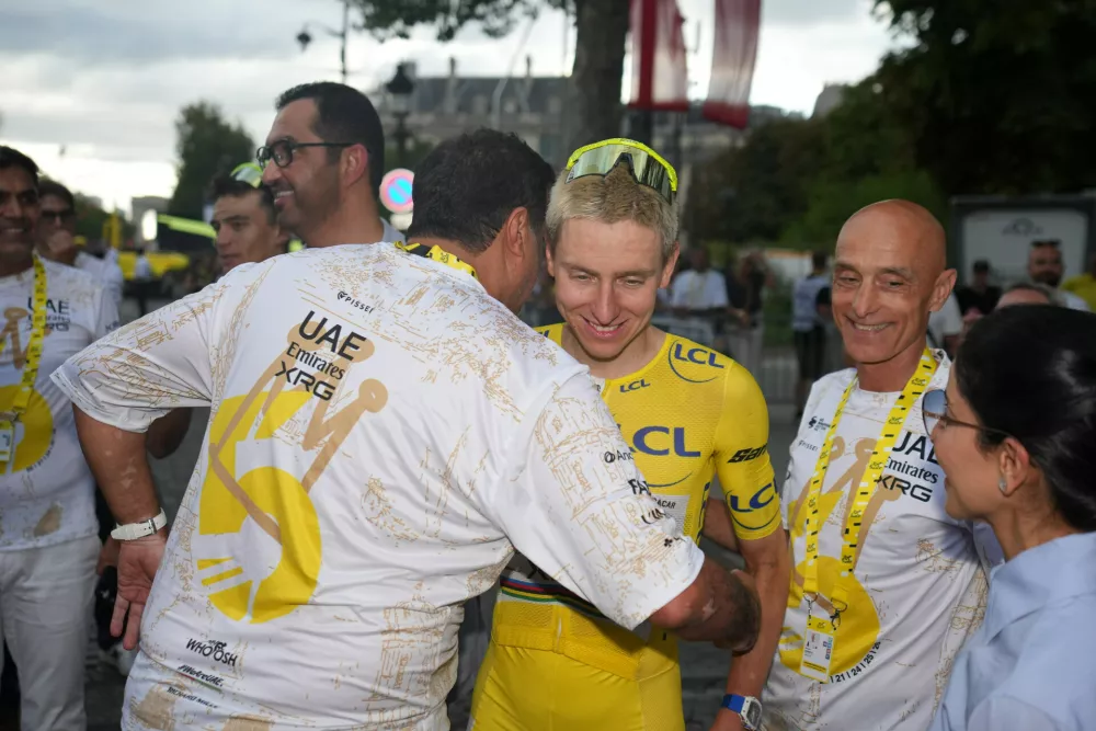 Slovenia's Tadej Pogacar, wearing the overall leader's yellow jersey, celebrates with his teammates after the last stage of the Tour de France cycling race with start and finish in Paris, Sunday, July 26, 2026. (AP Photo/Mosa'ab Elshamy)