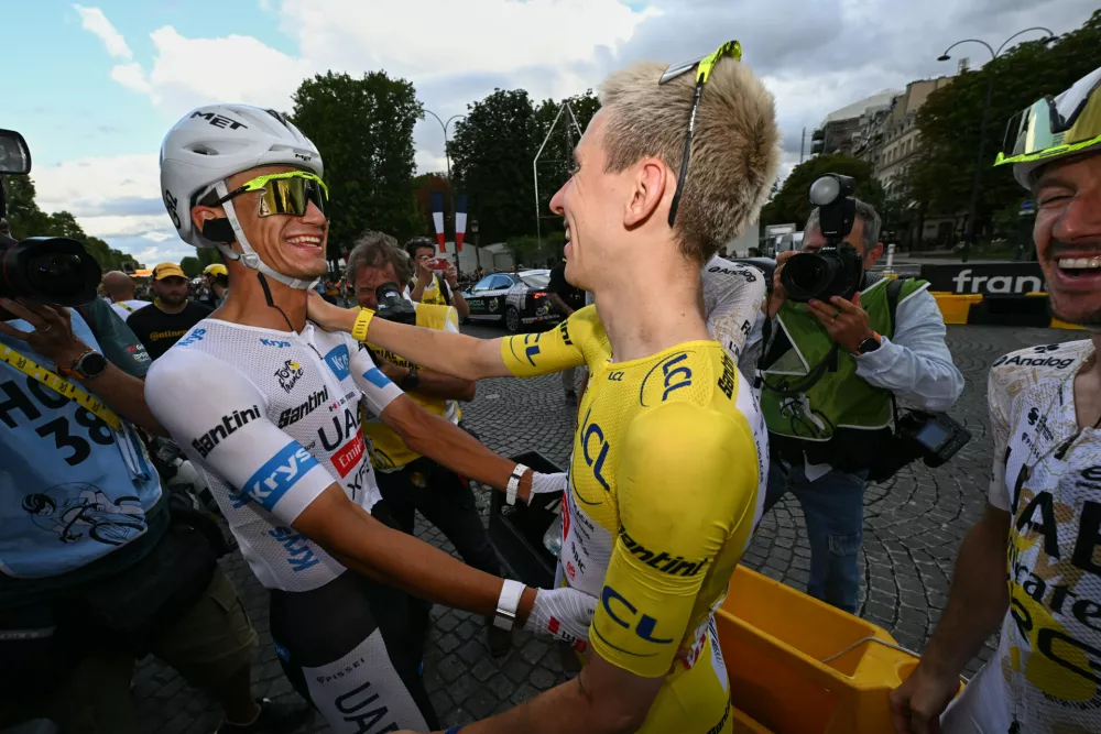Slovenia's Tadej Pogacar, wearing the overall leader's yellow jersey, celebrates with his UAE Team Emirates XRG teammate Mexico's Isaac Del Toro after the last stage of the Tour de France cycling race in Paris, Sunday, July 26, 2026. (AP Photo/Dario Belingheri/Pool Photo via AP)