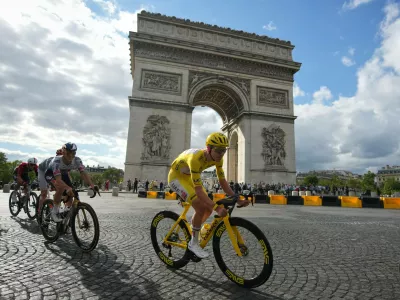 Slovenia's Tadej Pogacar, wearing the overall leader's yellow jersey, rides in front of the Arc de Triomphe during the last stage of the Tour de France cycling race with start and finish in Paris, Sunday, July 26, 2026. (AP Photo/Mosa'ab Elshamy)