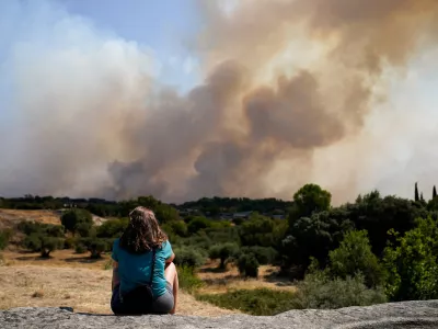 A woman looks as smoke rises from a wildfire in San Martin de Valdeiglesias, Community of Madrid, Spain, July 26, 2026. REUTERS/Ana Beltran  TPX IMAGES OF THE DAY