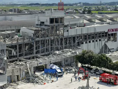 In this aerial image taken with a drone, responders work outside AEON Mall Kumamoto after an explosion occurred following an earthquake, in Kashima, Kumamoto Prefecture, southern Japan, Thursday, July 30, 2026. (Koji Harada/Kyodo News via AP)