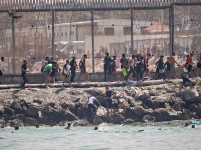 Migrants cross from Morocco into the Spanish enclave of Ceuta, Thursday, July 30, 2026. (AP Photo/Antonio Sempere)