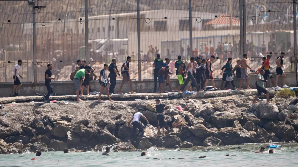 Migrants cross from Morocco into the Spanish enclave of Ceuta, Thursday, July 30, 2026. (AP Photo/Antonio Sempere)