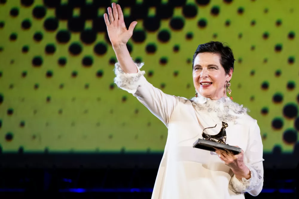 Actress Isabella Rossellini of Italy poses with her "Excellence Award 2026" while standing on the Piazza Grande stage at the 79th Locarno Film Festival, in Locarno, Switzerland, Wednesday, Aug. 5, 2026. (Jean-Christophe Bott/Keystone via AP)